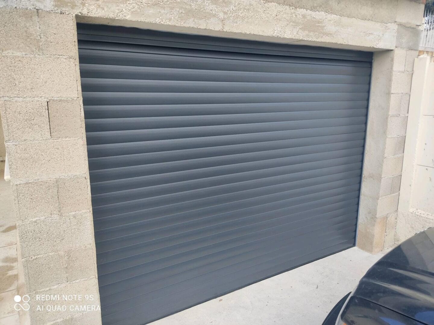 Installation d'une porte de garage enroulable motorisé sur mesure - Menuiz